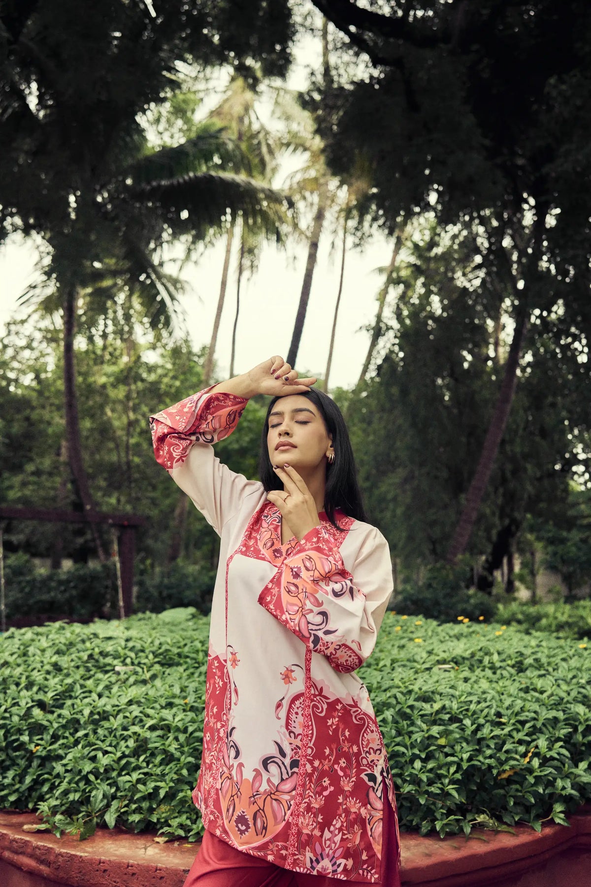 Model posing in a crimson paisley co-ord set