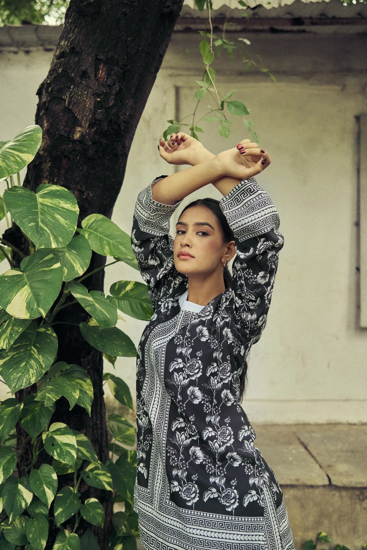Model with arms raised in a black and white floral set