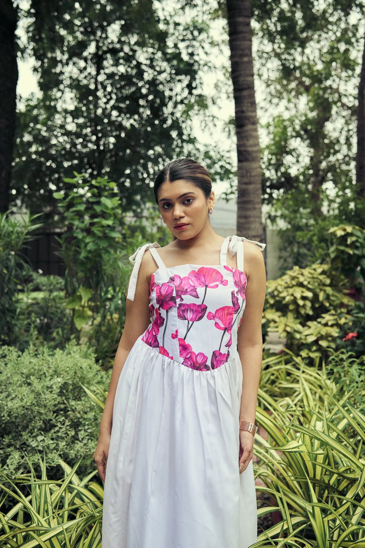 Model in a white dress with a pink poppy print bodice