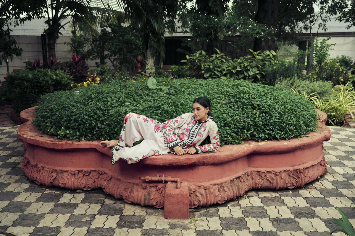 Model reclining on a curved terracotta garden bench in a printed co-ord set